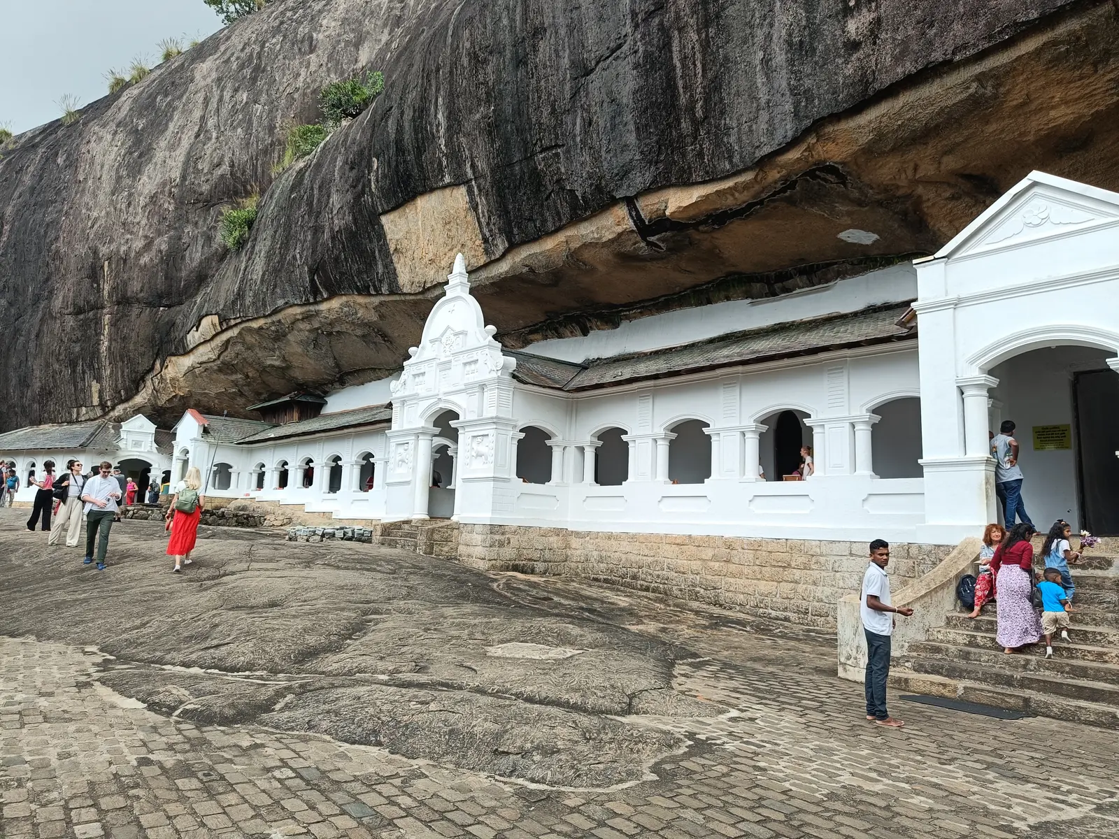 White temple buildings sheltered beneath the rock at Dambulla