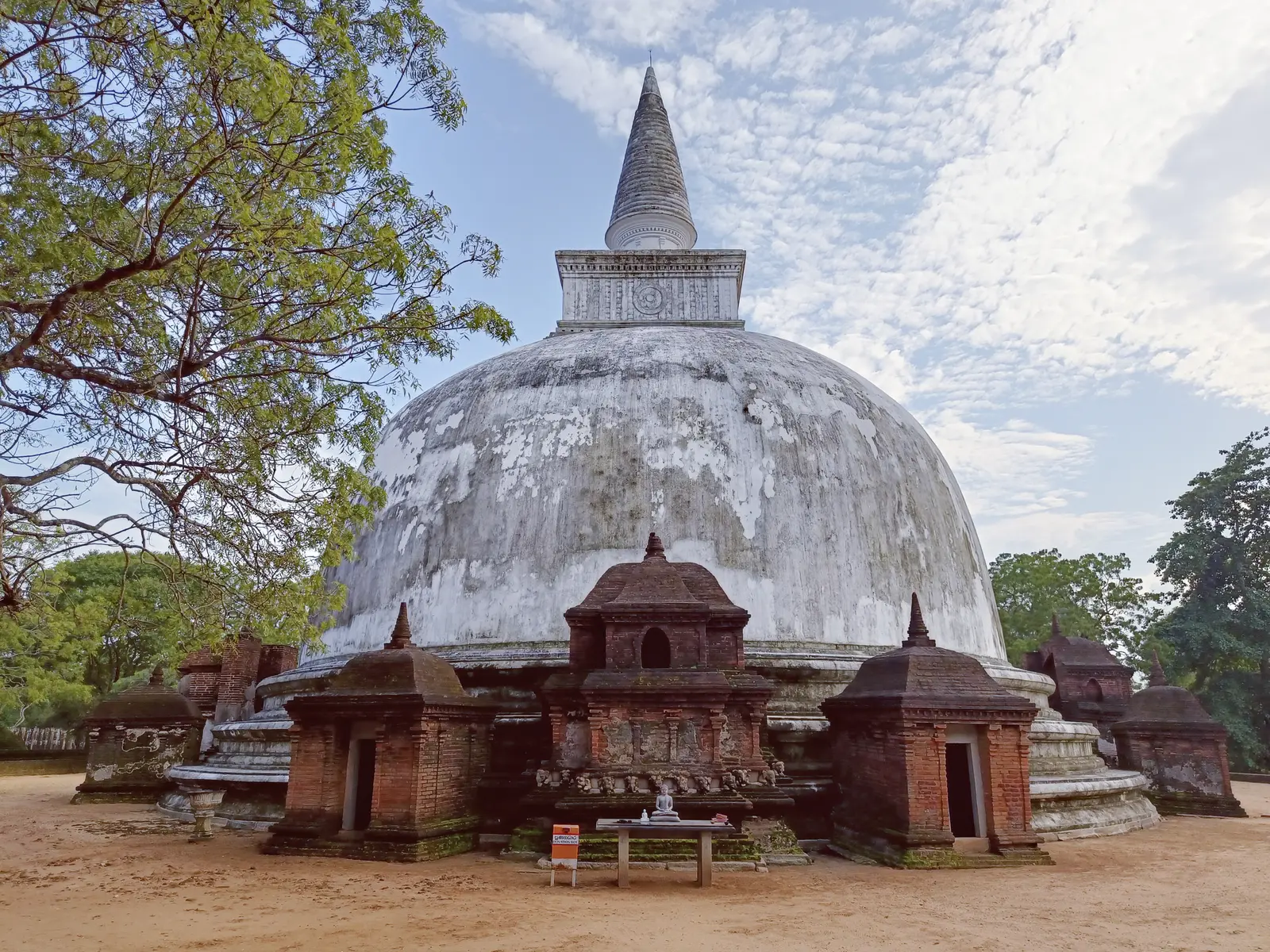 A historic white stupa among trees in Polonnaruwa